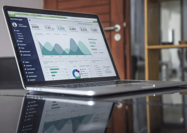 Laptop on office table displaying BI dashboard with white background